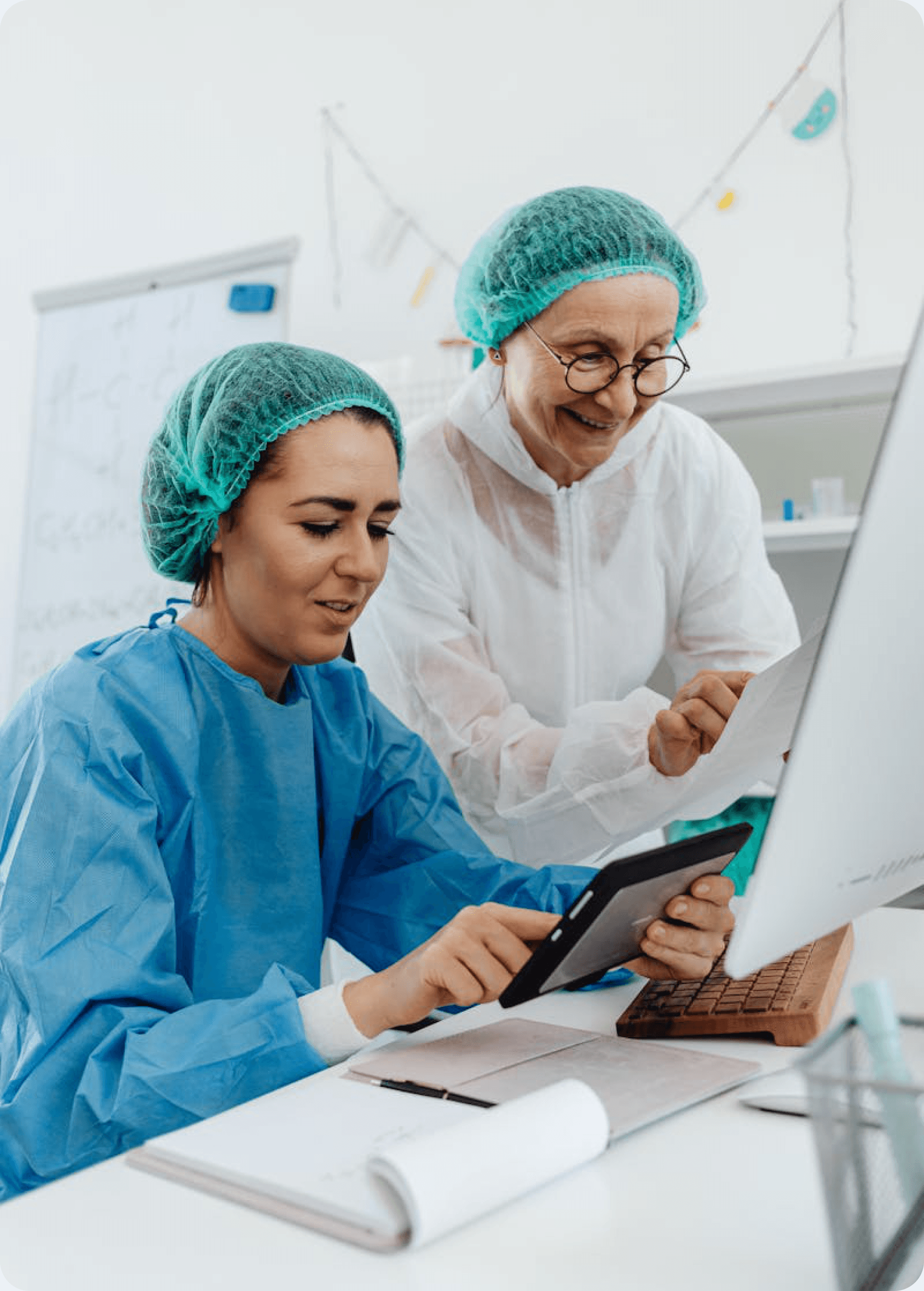 Two clinicians reviewing patient information on a tablet in a hospital setting