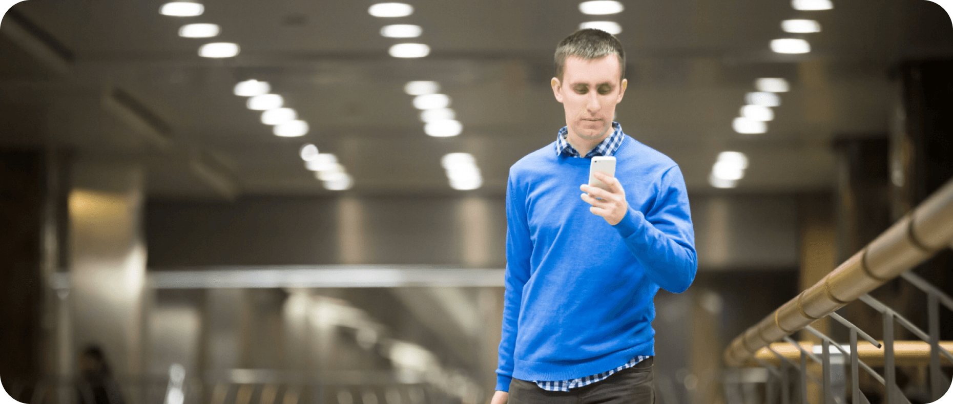 Traveler reviewing trip details on a smartphone in a bright terminal