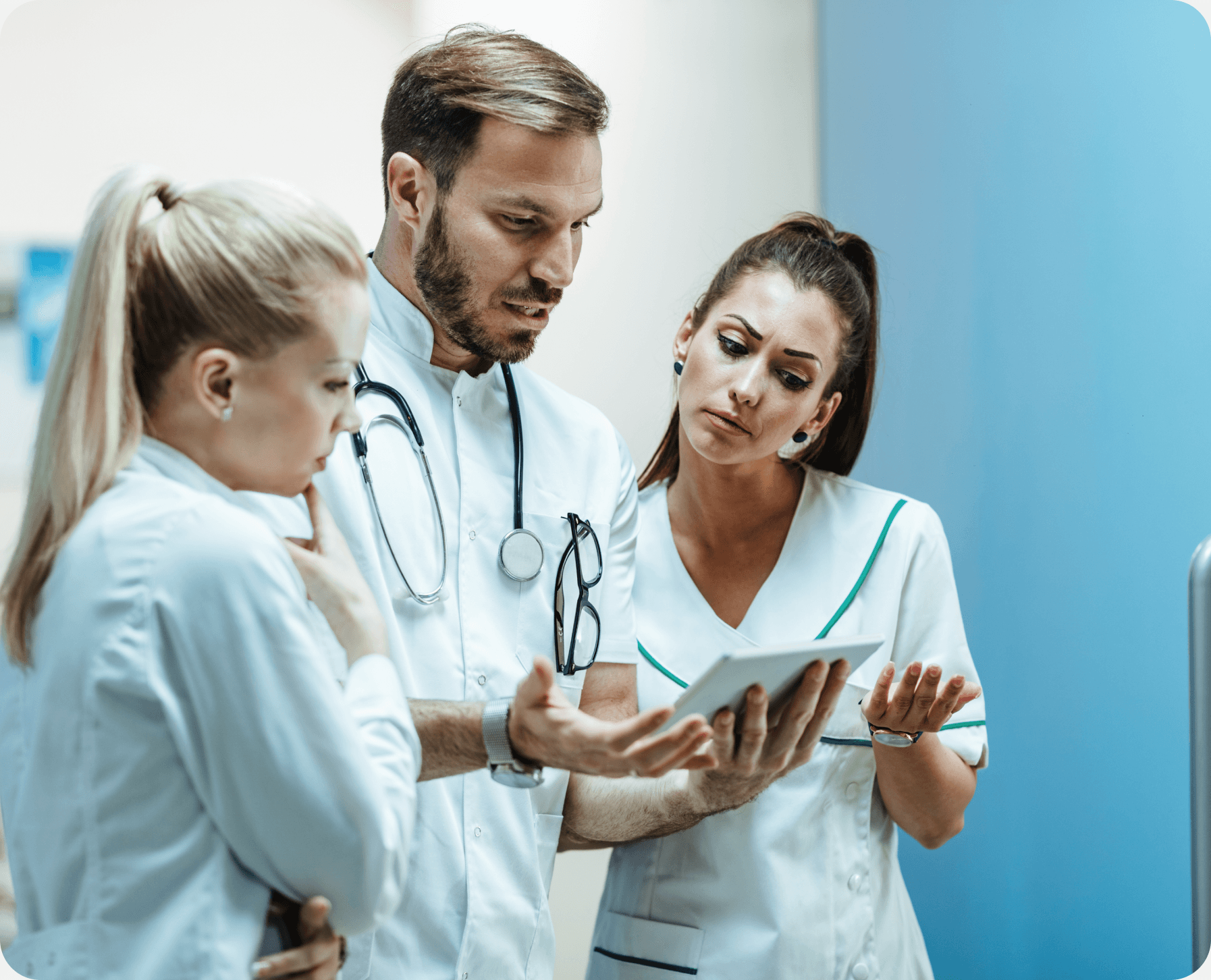 Clinical team collaborating over a tablet in a hospital setting