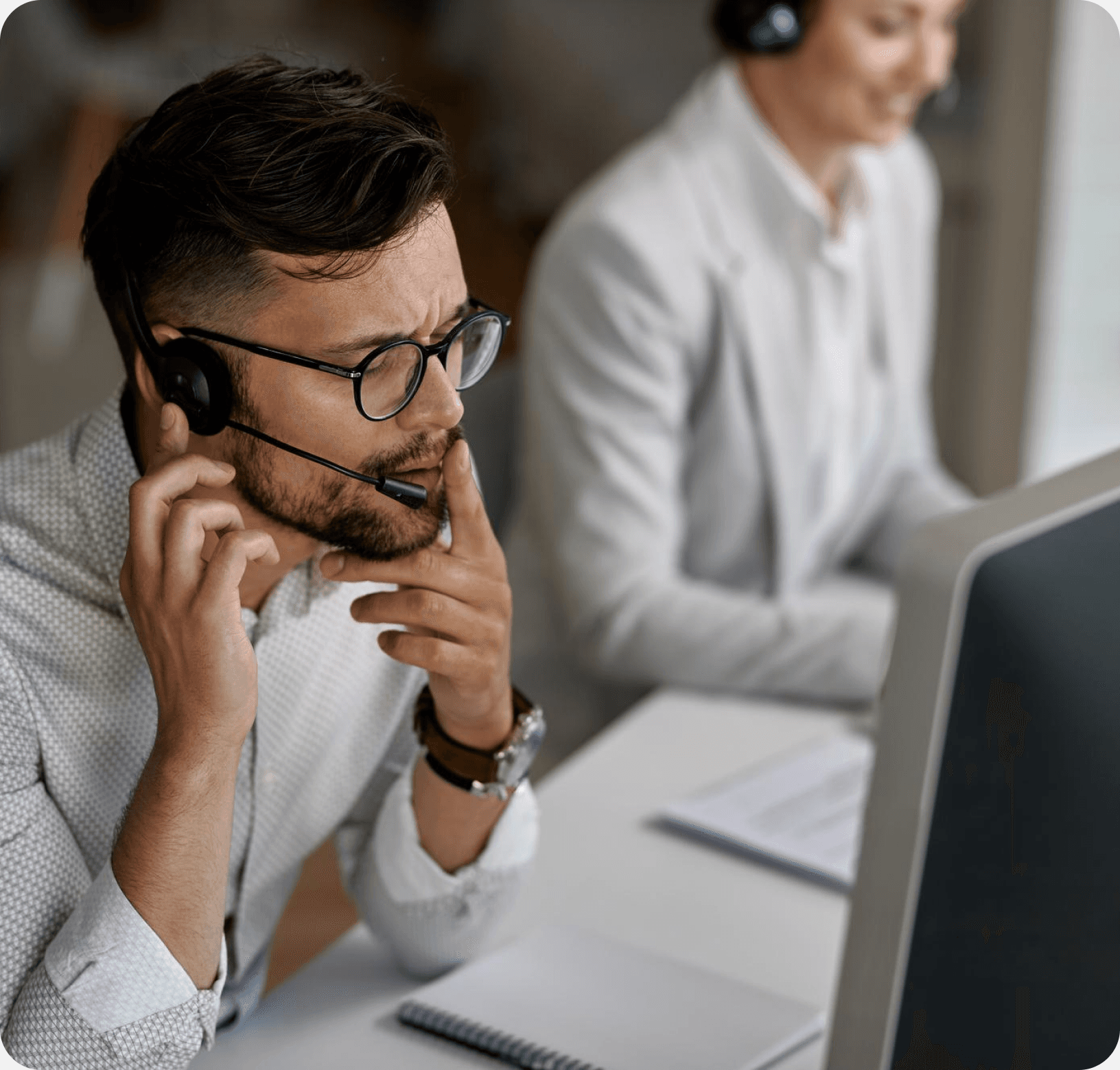 Support specialist wearing a headset while reviewing placement details on a computer